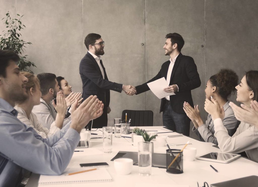 client et commercial se serrant la main suite à un contrat signé